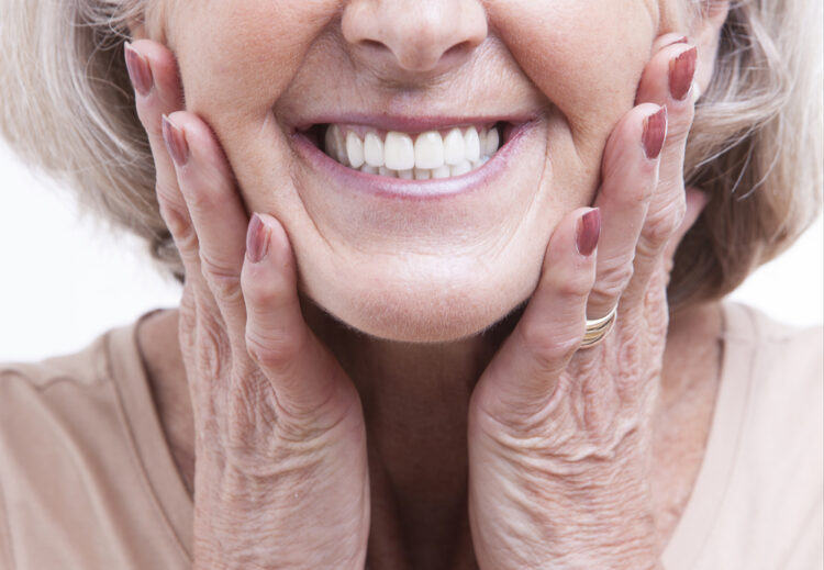 Closeup photo of an elderly woman while showing her teeth