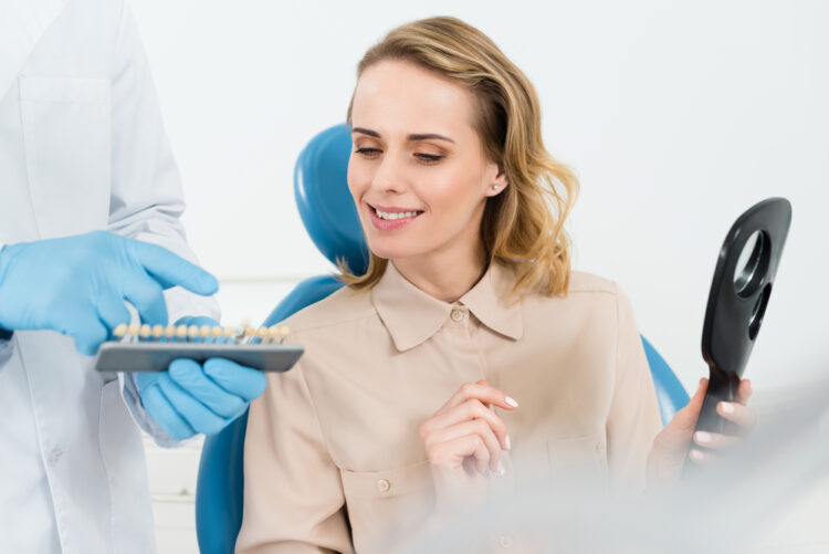 A woman in a dentist chair, preparing for dental care, possibly a dental implant.